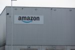 amazon-warehouse-iStock-1352393070.jpg A metal grey warehouse building, with "Amazon" written in black lettering across the top left