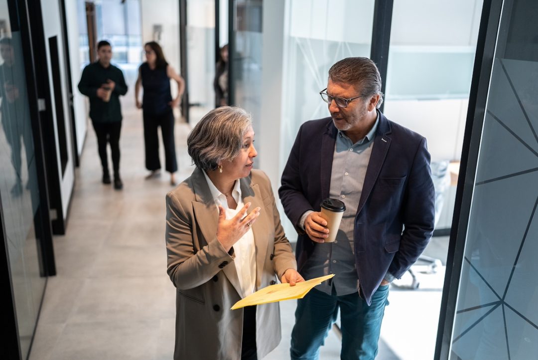 Businesspeople walking and talking in the office's corridor