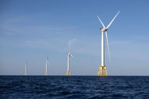 FOUR WIND TURBINES AT SEA.